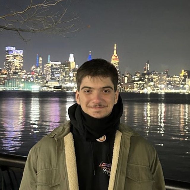 Mehmet Bisen, night skyline behind him